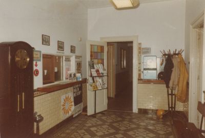 Hal-van-Gemeentehuis
Gemeentehuis, Voorstraat 35
Voor de nieuwbouw: het entree;
links burgemeesterskamer;
rechts: deur secretariskamer. 
De klok (rechts) is een geschenk bij de opening van het gemeentehuis na de verbouwing van ca. 1950.
Zie ook foto-s 5-12-1, 1A, 2 en 2A
