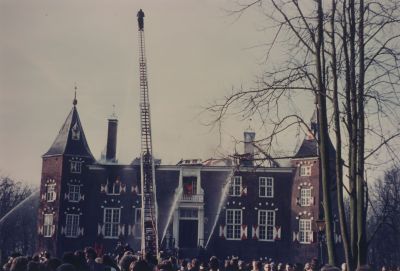Brand-op-het-kasteel
Kasteelbrand.
De brand  woedt binnen in het kasteel nadat het dak is ingestort.
De brandweerman boven op de ladder is een lid van het Weesper brandweerkorps , dat bijstand verleend heeft.
