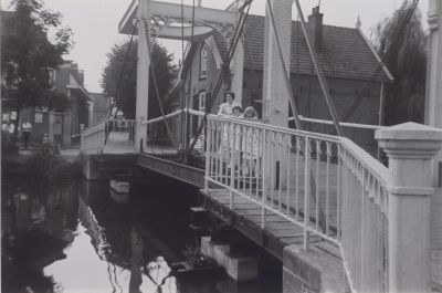 De-ophaalbrug-in-het-centrum
L van Weeghel Anneke Verschuren en Mevr Verschuren  De brug was niet zo lang geleden in ca 1950 geschilderd door Richard Baar en Bernard Portengen-   Ze waren in dienst bij Frans Stijvers
Trefwoorden: Brug