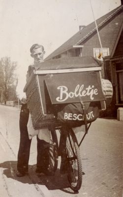 Bakker-Arie-Roukens-met-transportfiets
Bakker Arie Roukens met zijn transportfiets.
Hiermee ging hij met brood langs zijn klanten.
Hij maakte tevens reclame voor het Bolletje beschuit.
