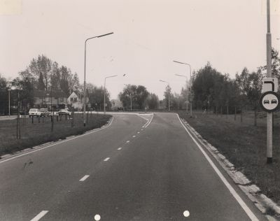 Dorpszicht
De nieuwe Overmeerseweg is aangelegd op de gedempte Reevaart rond 1970.
Op de kruising naar links de Randweg, naar rechts de  oude Overmeerseweg.
De woning rechts in het rijtje is thans ( in  2006 ) de winkel/schoenmakerij van G Kroon.
De witte woning is eigendom van de heer F.Welle.
Trefwoorden: Schoenmaker; gedempte Reevaart